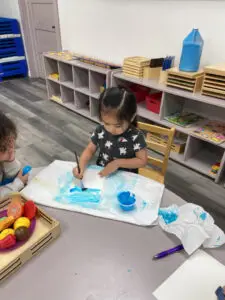 Toddler painting at an art table