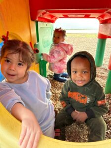 Two toddlers playing on the playground