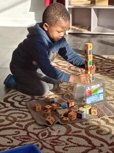 Child building a tower with wooden blocks