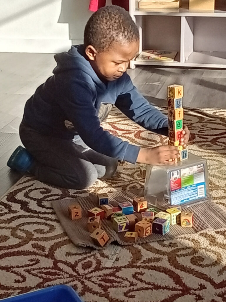 Child building a block tower in a Sunshine Daycare classroom